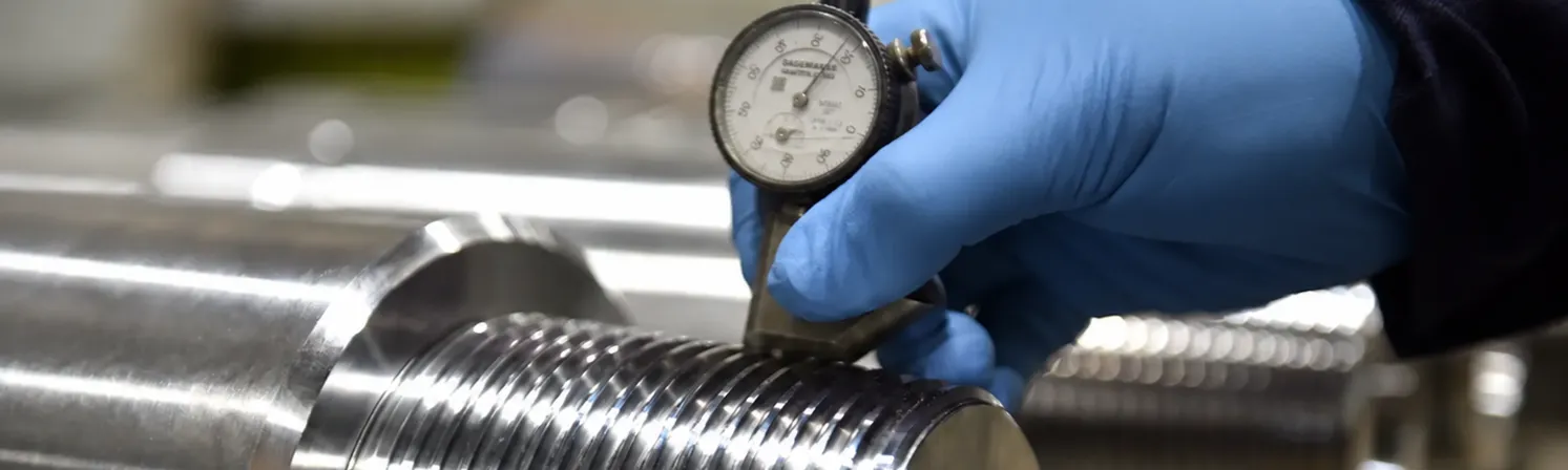 Precision thread inspection of oil and gas equipment using a dial gauge.